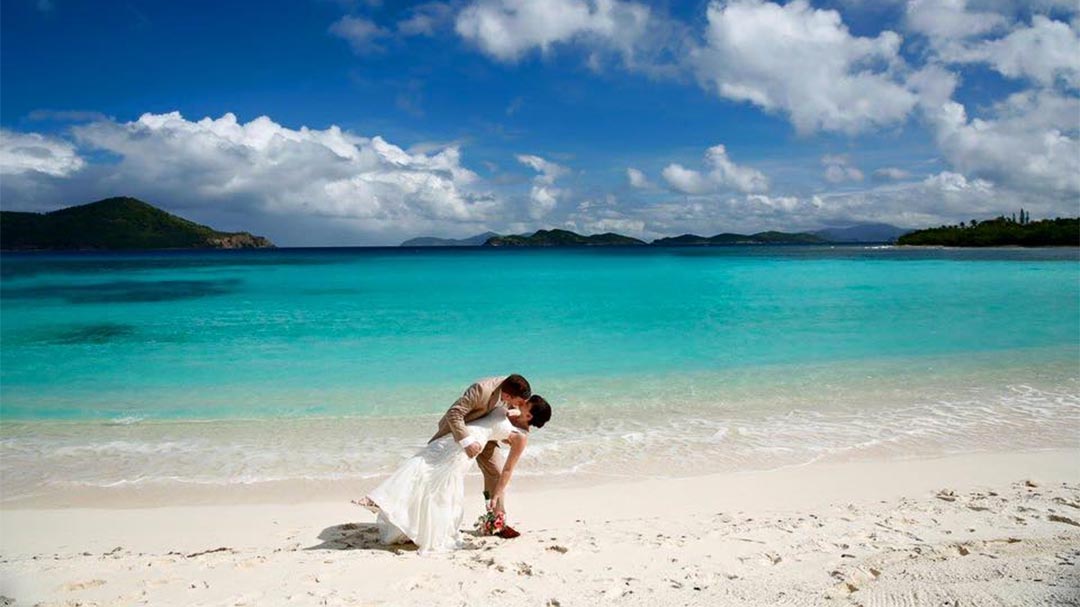 Wedding couple kissing on the beautiful Lindquist Beach of Saint Thomas in the US Virgin Islands.