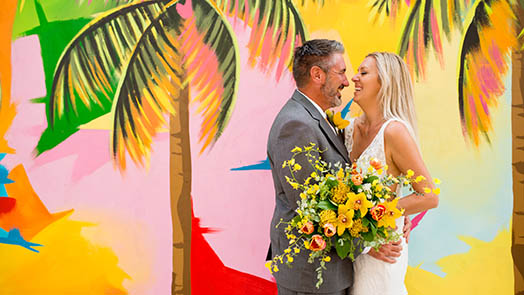 Wedding couple in front of colorful mural in St. Thomas US Virgin Islands.