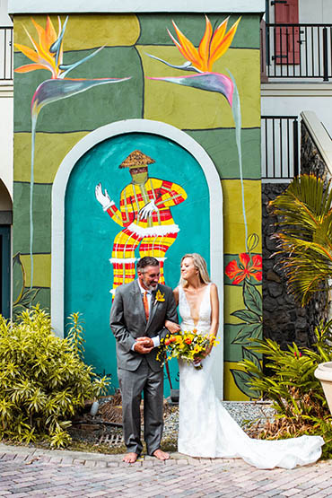 Happily married couple in front of a colorful mural in St. Thomas.