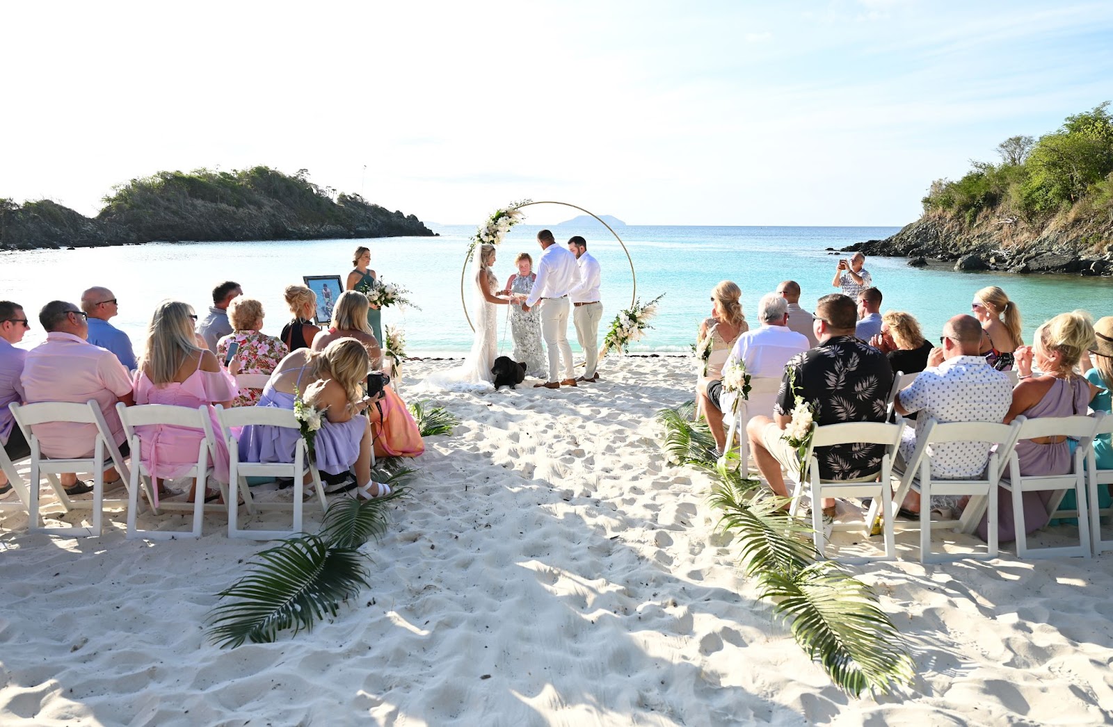 Married couple walking happily barefoot in the sand in St. Thomas.