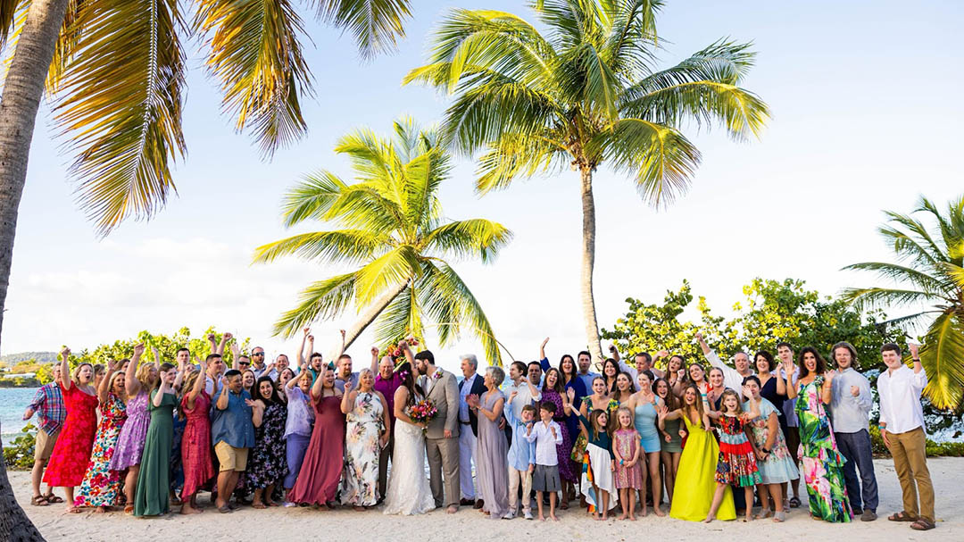 Tiffany & John - Sapphire Beach Ceremony & Reception 007 Husband holding wife's hand in front of Greetings from St Thomas mural in the USVI.